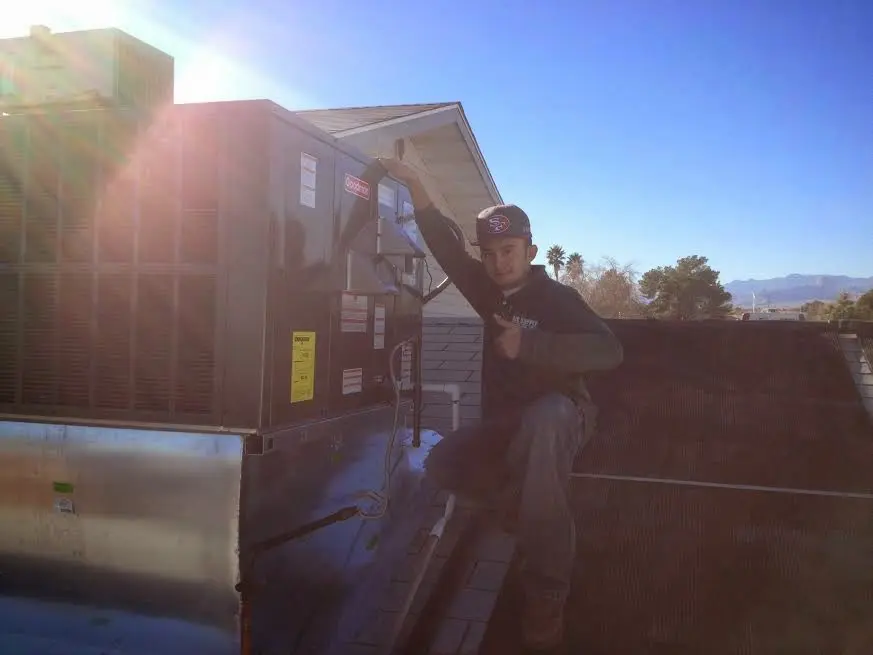 HVAC technician performing Air Duct Repair on a rooftop unit in Loudon